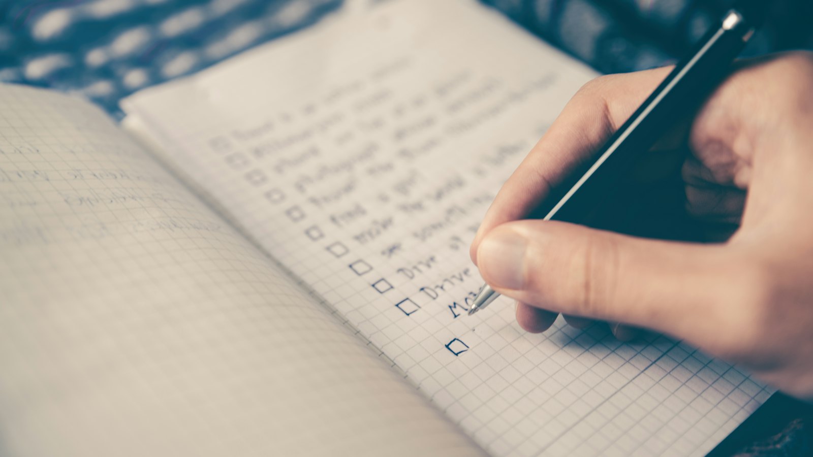 Personne écrivant une liste dans un carnet