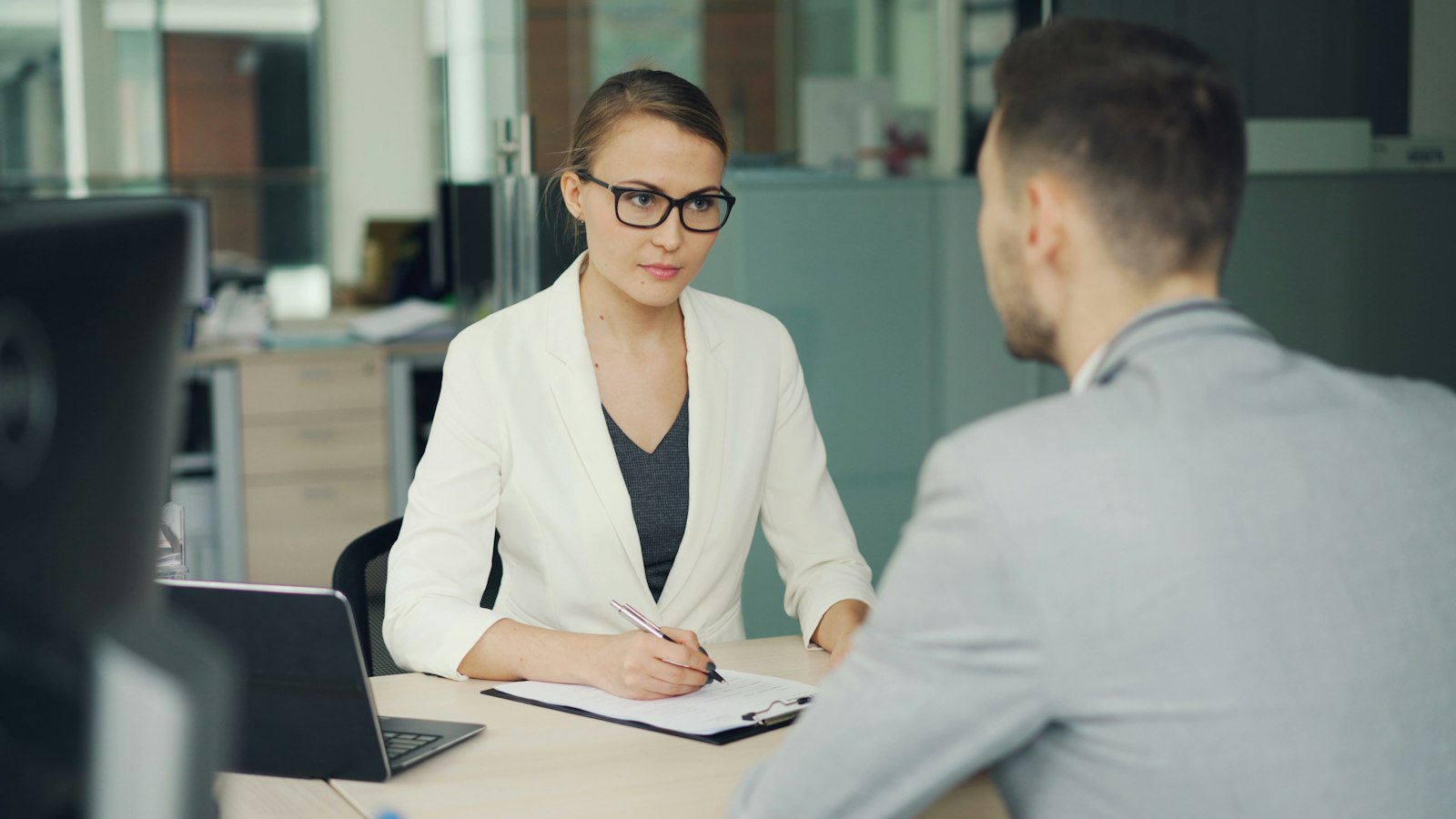 Une recruteuse interroge un candidat à son bureau