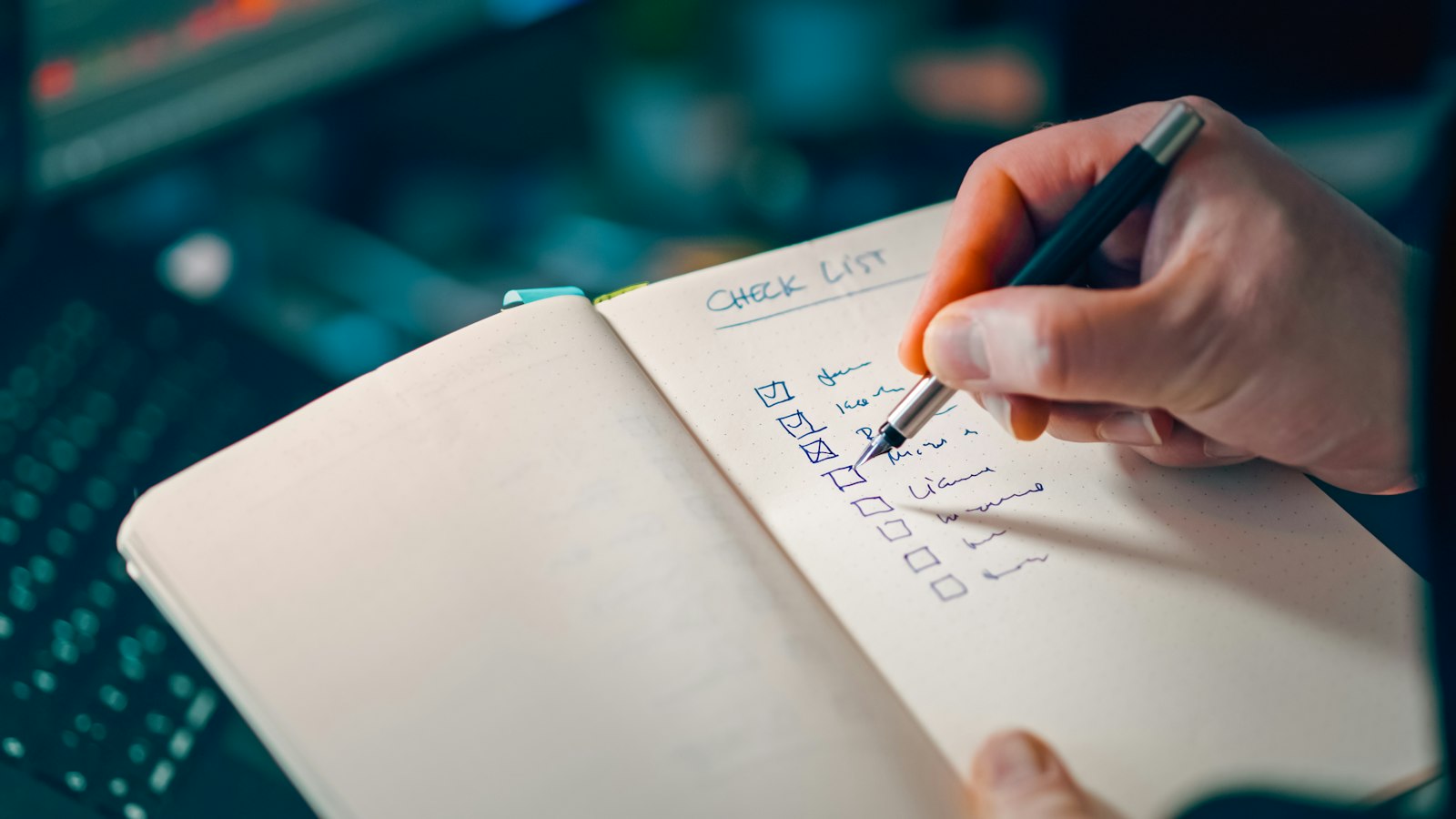 Une main coche une liste dans un carnet