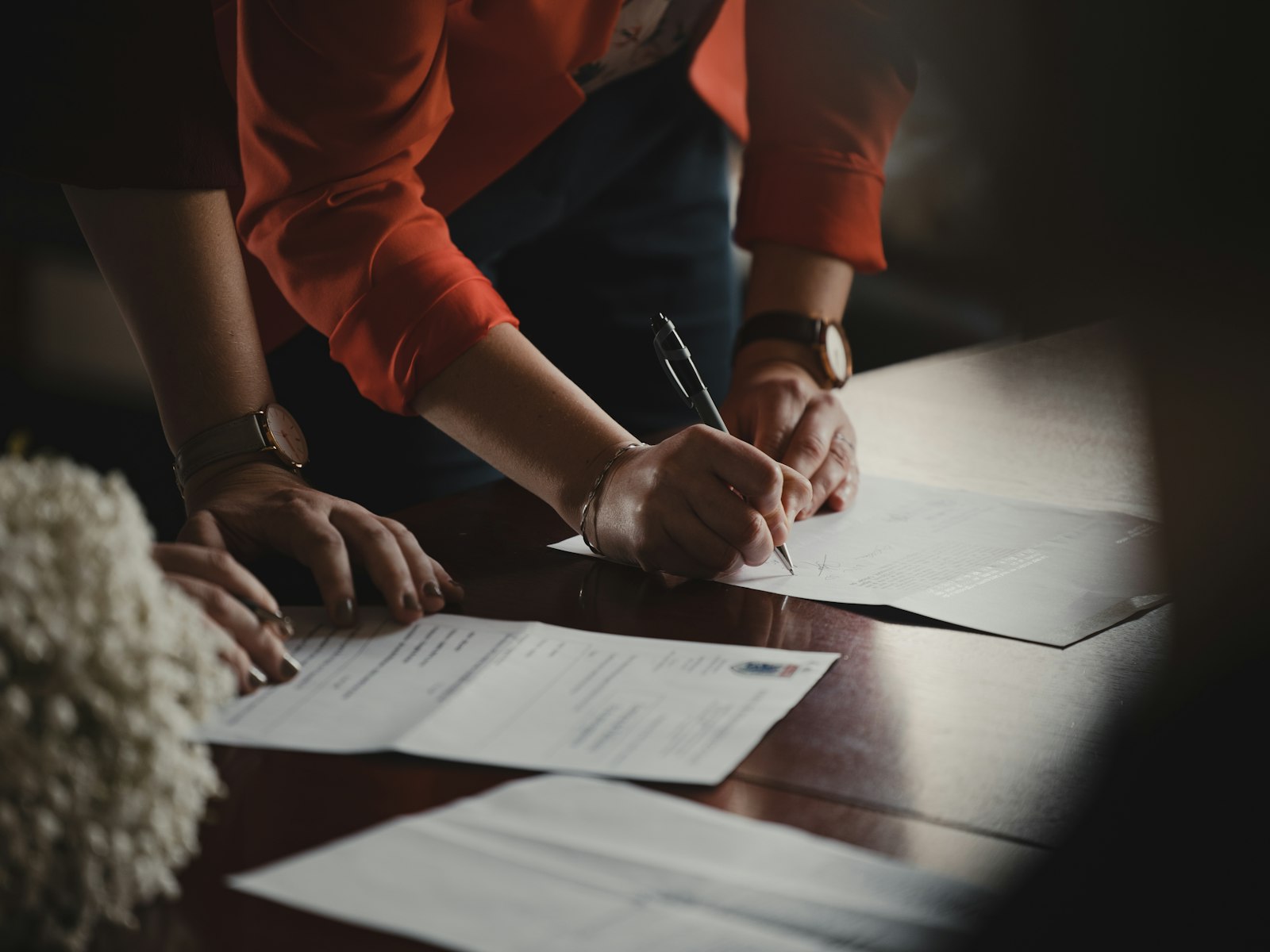 Deux personnes relisent et annotent des documents sur une table