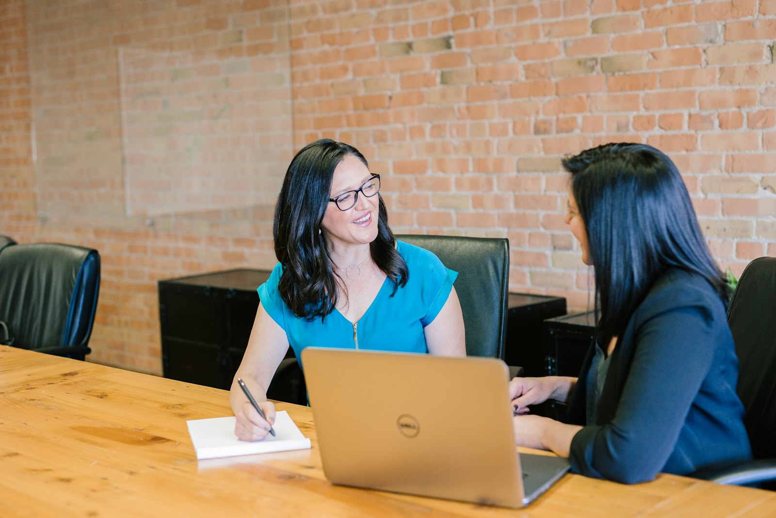 Deux femmes échangent autour d'une table de travail